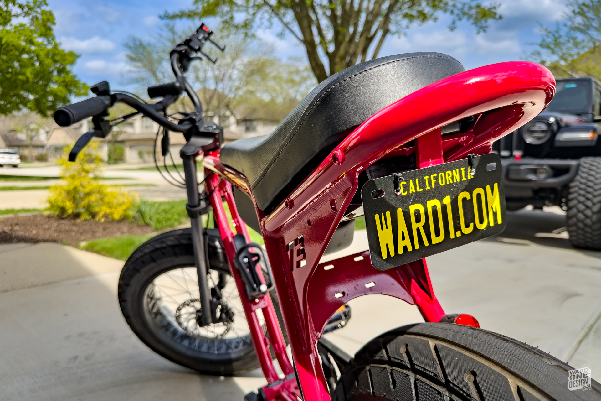 Electric bicycle with California license plate and custom website URL for eco-friendly transportation.