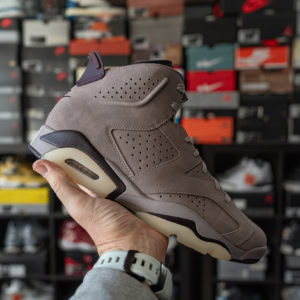 Air Jordan 6 A Ma Maniére sneaker showcased in a retail store with a background of sneaker boxes.