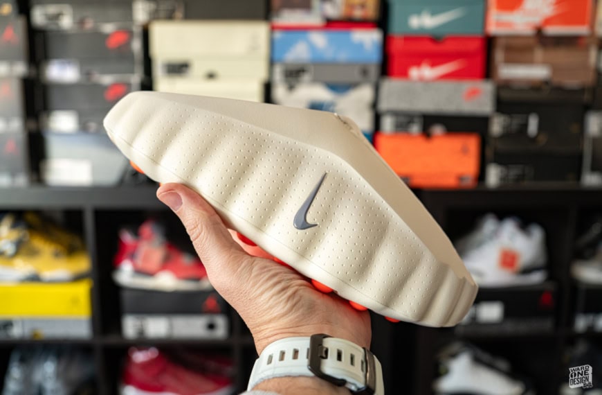 Nike Mind 001 sneaker, off-white color, with Nike swoosh logo, showcased in hand. Perfect for sneaker enthusiasts and collectors.