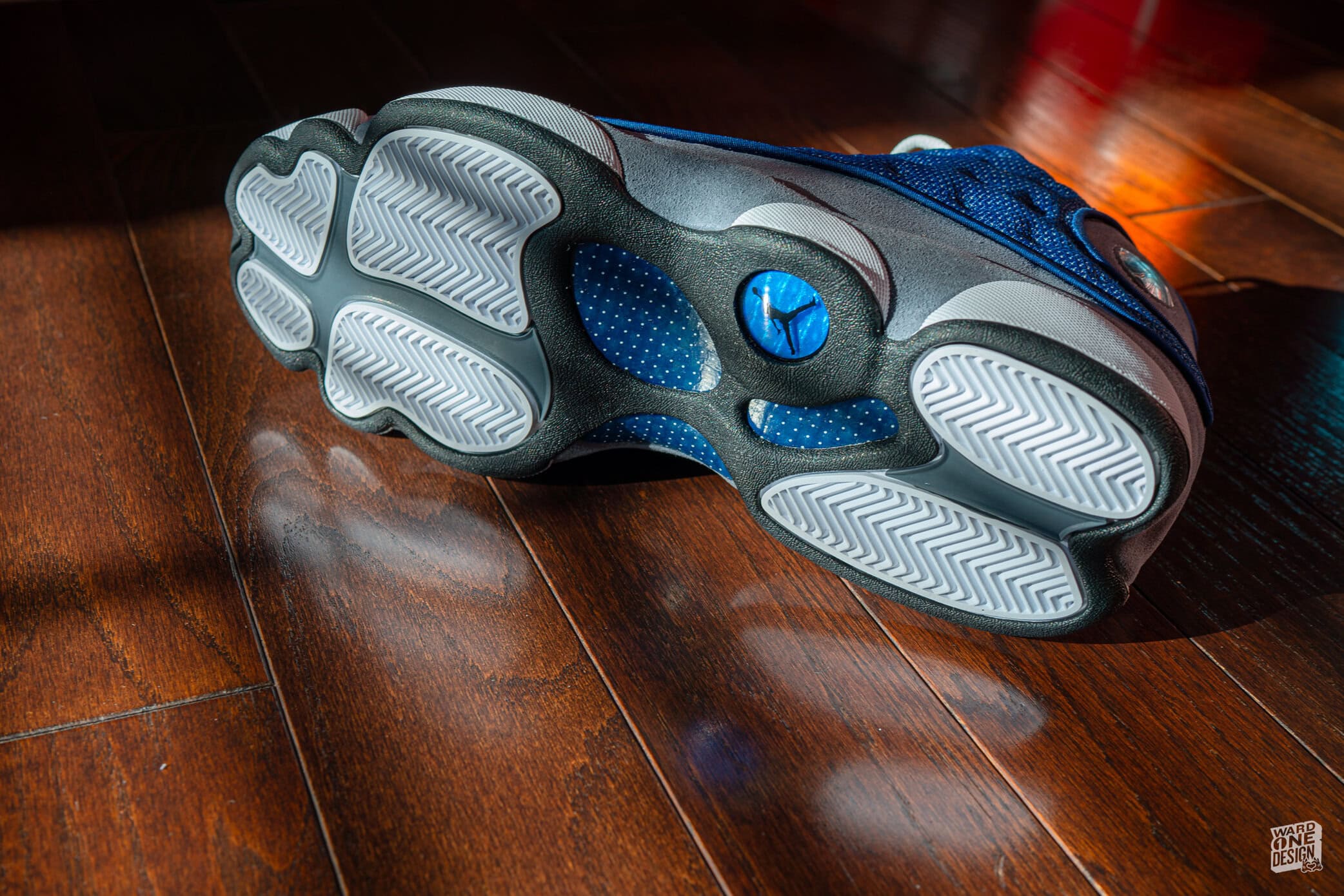 Close-up of blue and gray Air Jordan 13 Flint sneakers showing the sole and design details.