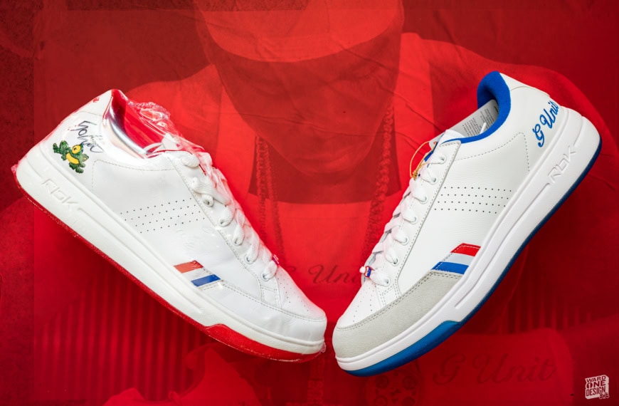 Pair of Reebok G-Unit G6 sneakers with white base, red and blue accents, showcased on a red background for promotional display.