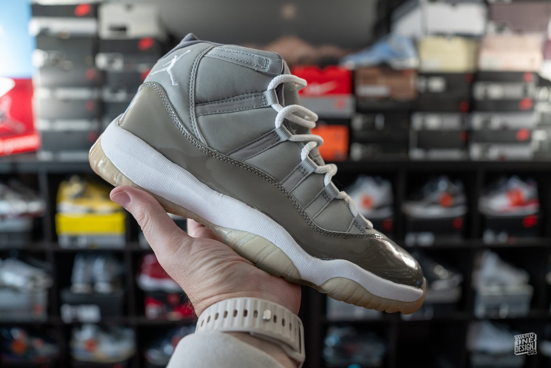 Close-up of Air Jordan 11 Retro Cool Grey sneakers held in hand, showcasing the iconic design and premium materials, perfect for sneaker enthusiasts and collectors.