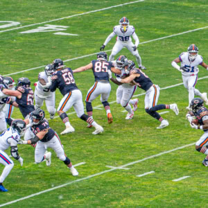 Action shot of Bears and Giants players during an intense NFL game on a green field.