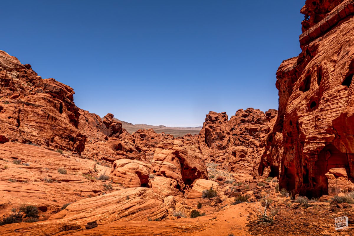 Breathtaking view of red rock formations and rugged canyon walls in a desert landscape under a clear blue sky. Perfect for outdoor adventure and nature photography.