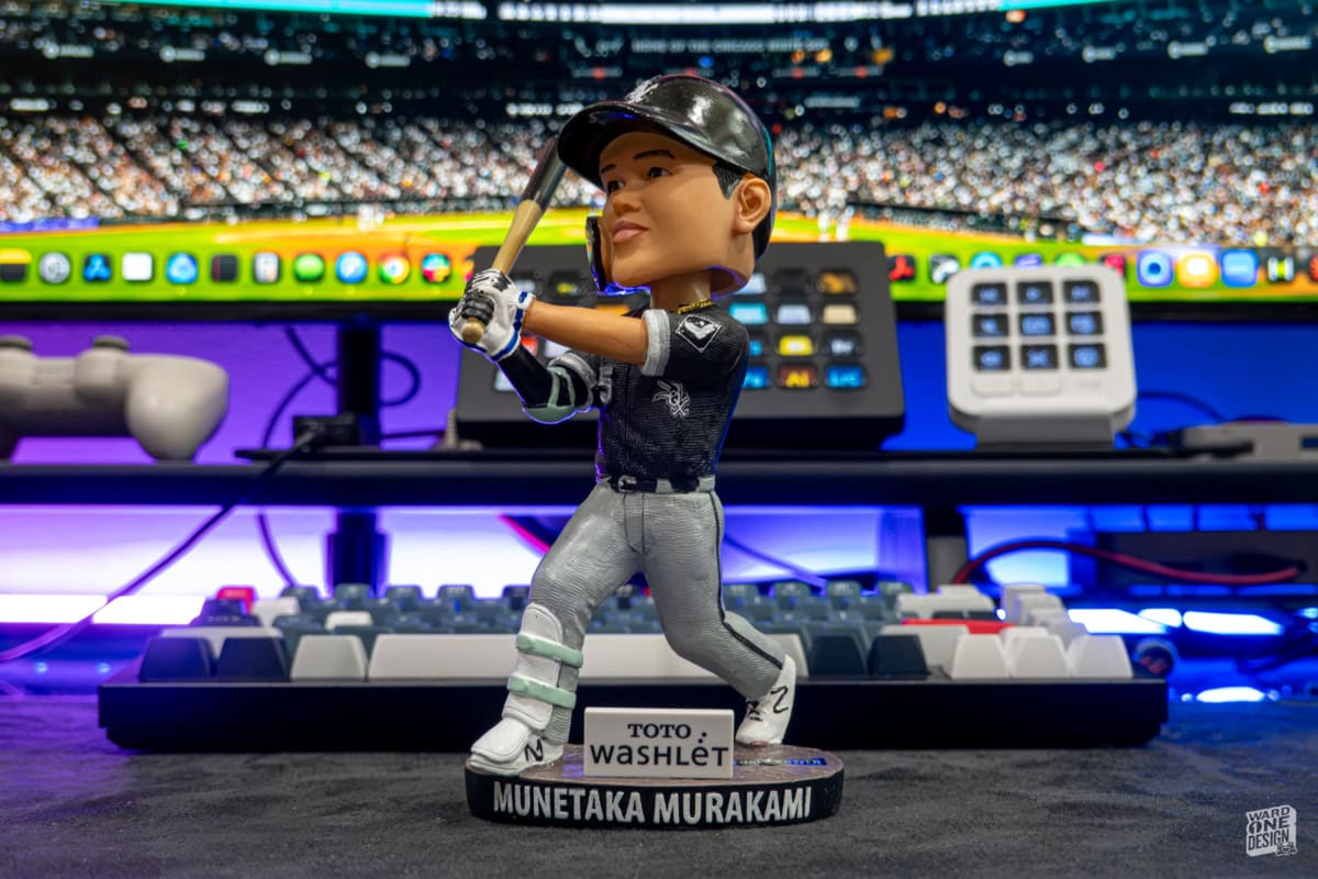 Detailed Munetaka Murakami baseball figurine with bat, wearing team uniform, on a display table at a sports event or exhibition.