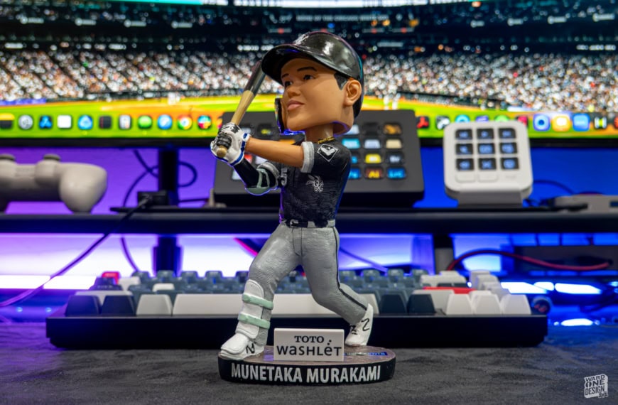 Detailed Munetaka Murakami baseball figurine with bat, wearing team uniform, on a display table at a sports event or exhibition.